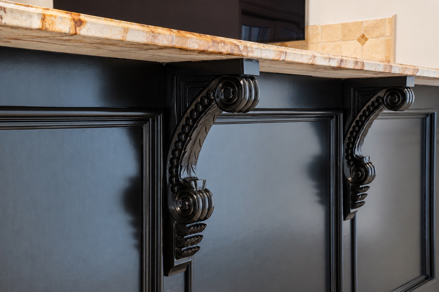 Close-up of carved corbels on a black refinished island showing the smooth sprayed finish by Genesis Pro Painting