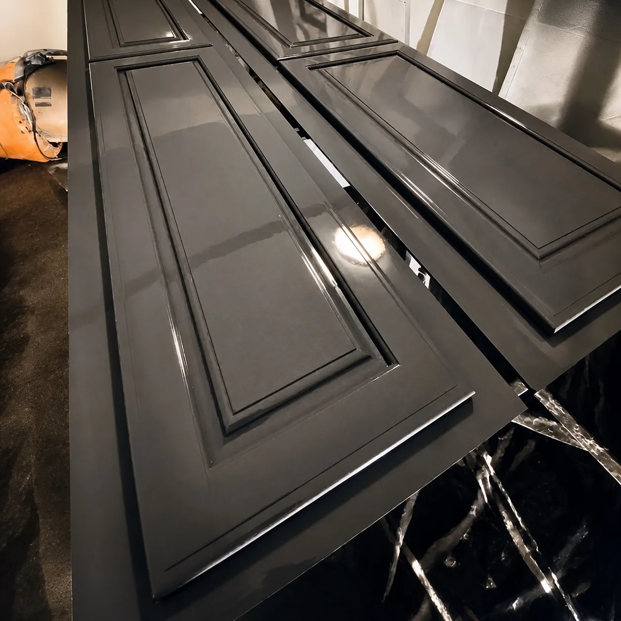 Cabinet doors laid out in the spray booth with a smooth grey sprayed finish, by Genesis Pro Painting in Westchester NY