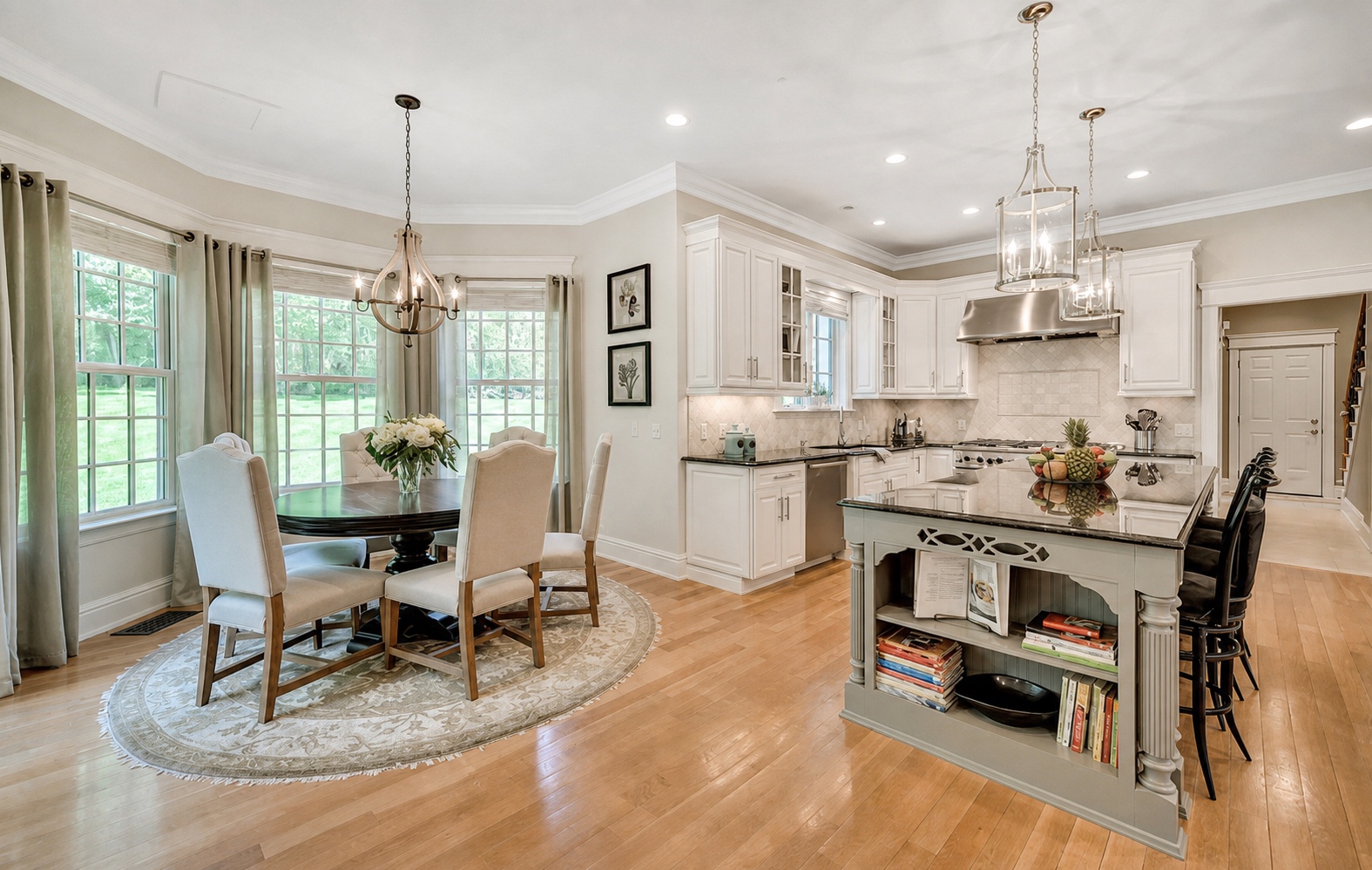 Open plan kitchen and dining room with refinished white cabinetry and a grey island by Genesis Pro Painting