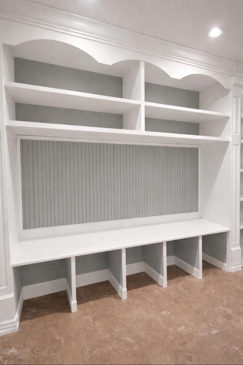 Finished custom built-in media wall with painted shelving, decorative trim, and beadboard panel by Genesis Pro Painting