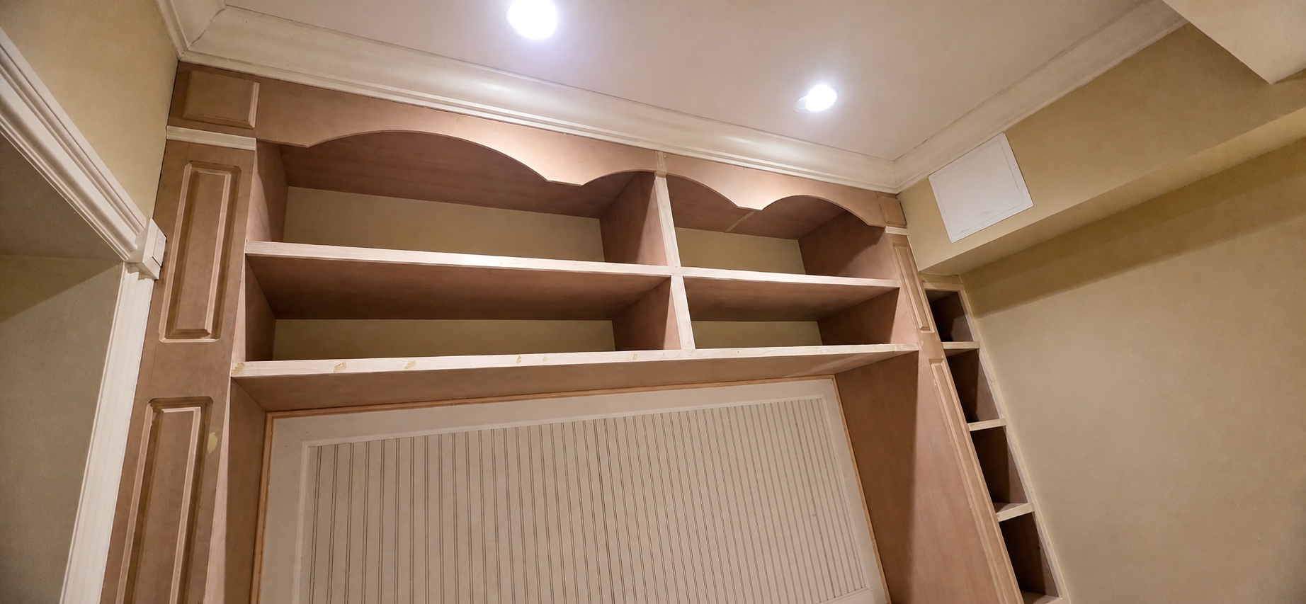 Custom built-in shelving and media wall under construction by Genesis Pro Painting