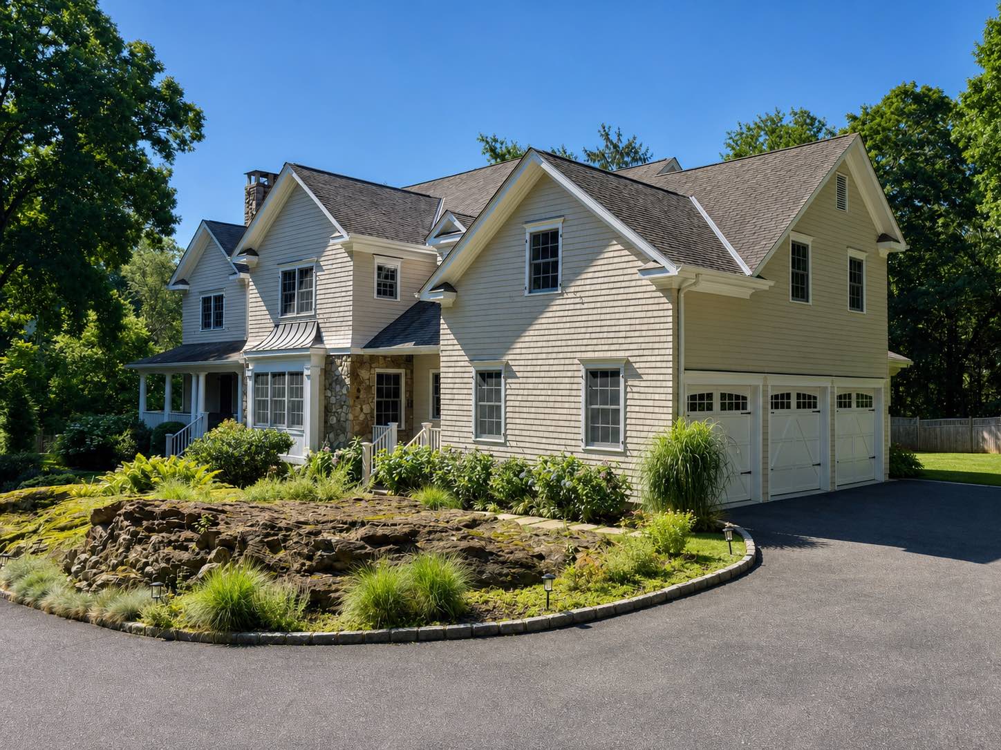 Exterior painted cedar shingle home with white trim, front porch, and stone accent by Genesis Pro Painting