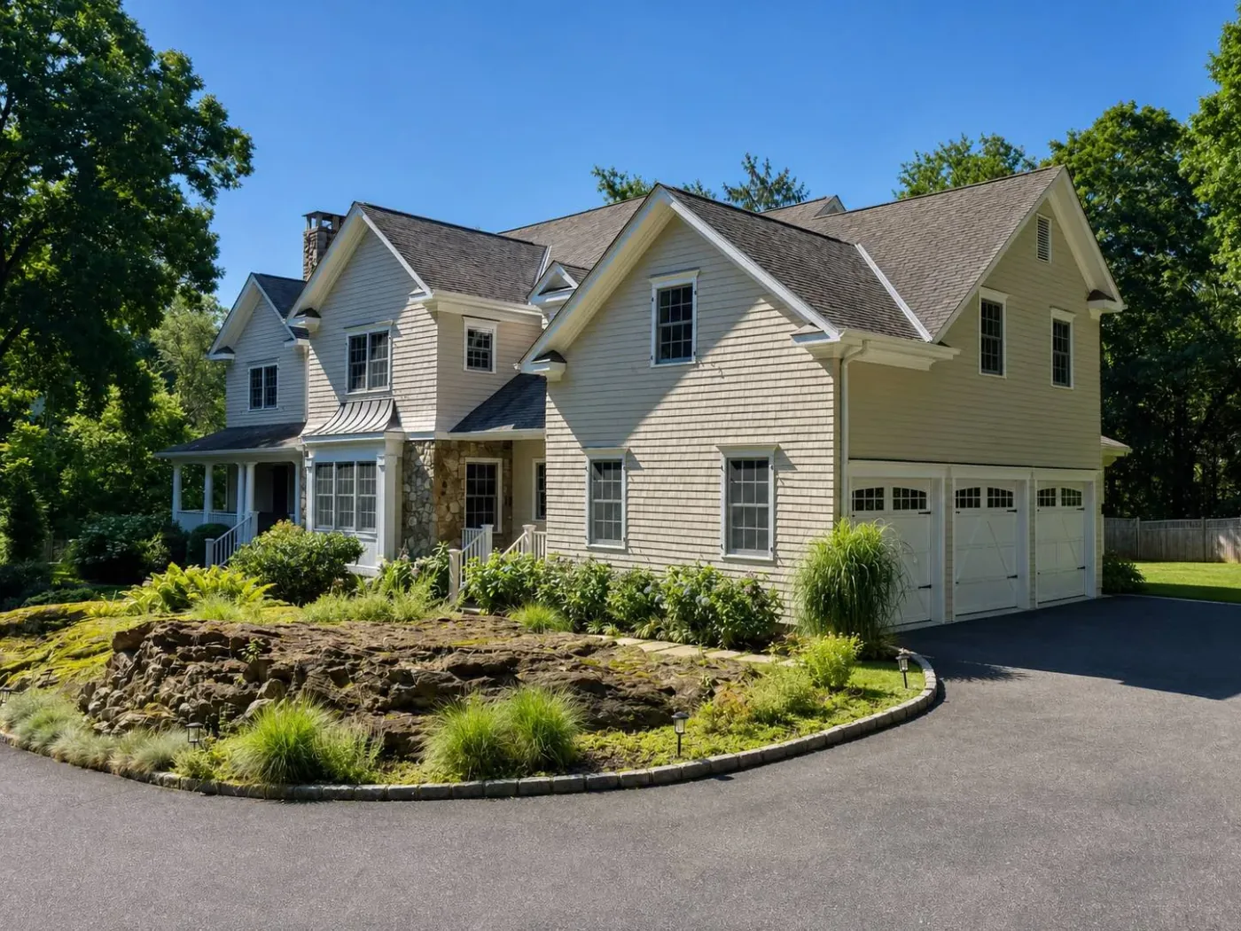 Exterior painted cedar shingle home with white trim, front porch, and stone accent by Genesis Pro Painting