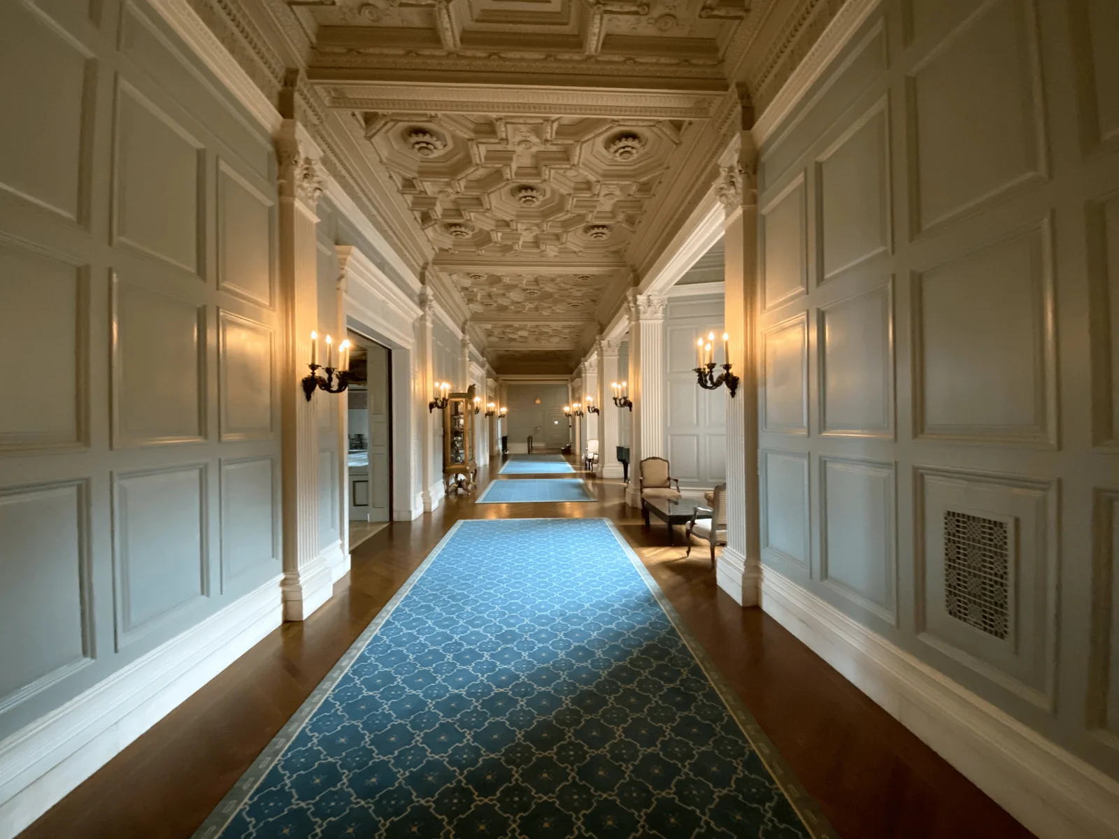 Interior painted hallway with white wall paneling, crown molding, and detailed trim by Genesis Pro Painting in Westchester NY