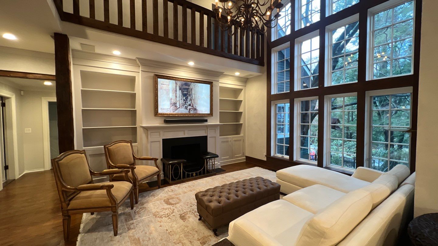 Interior painted living room with white built-ins, trim, and tall windows by Genesis Pro Painting