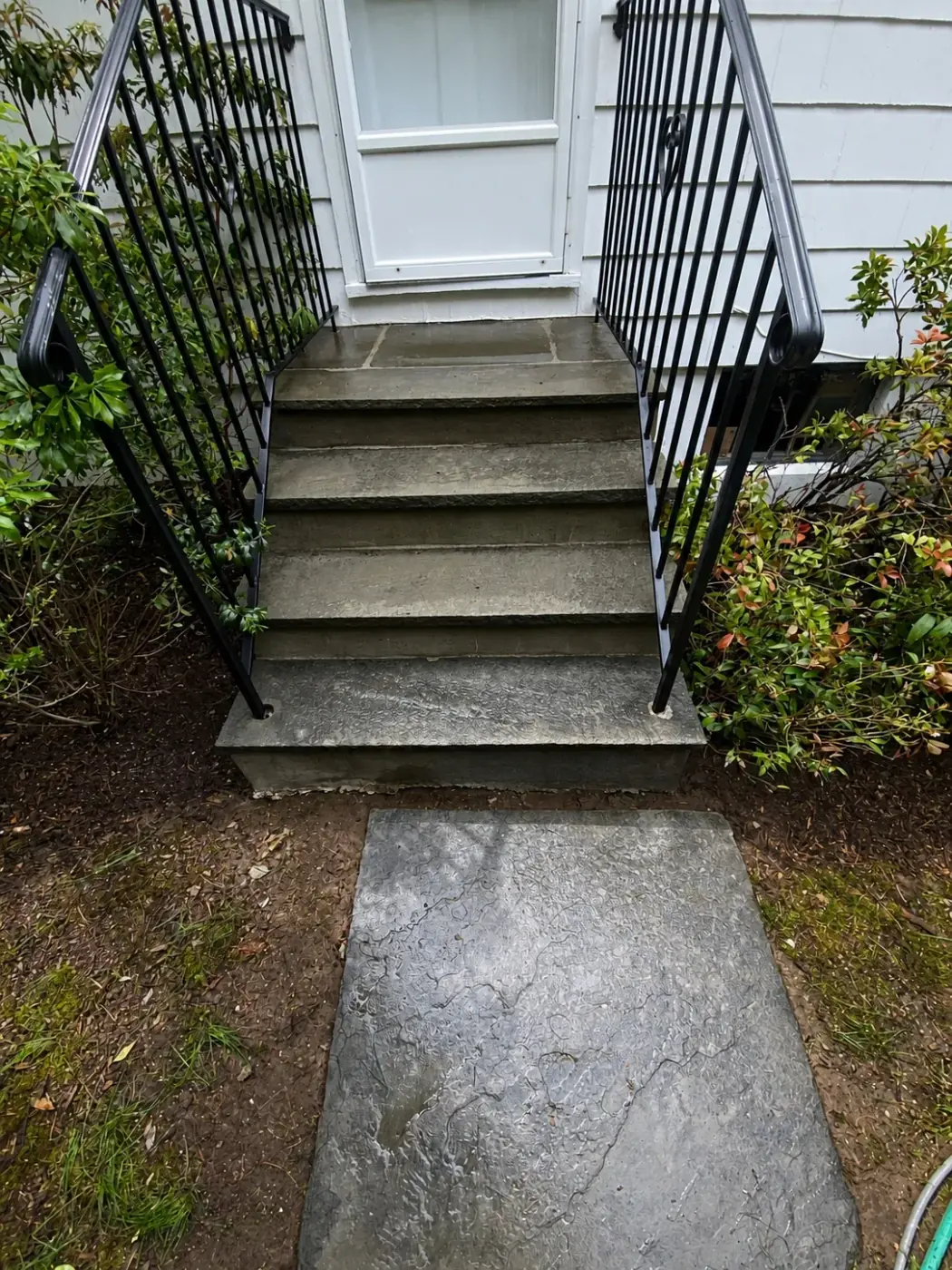 Pressure washed front steps and stone walkway with metal railings by Genesis Pro Painting