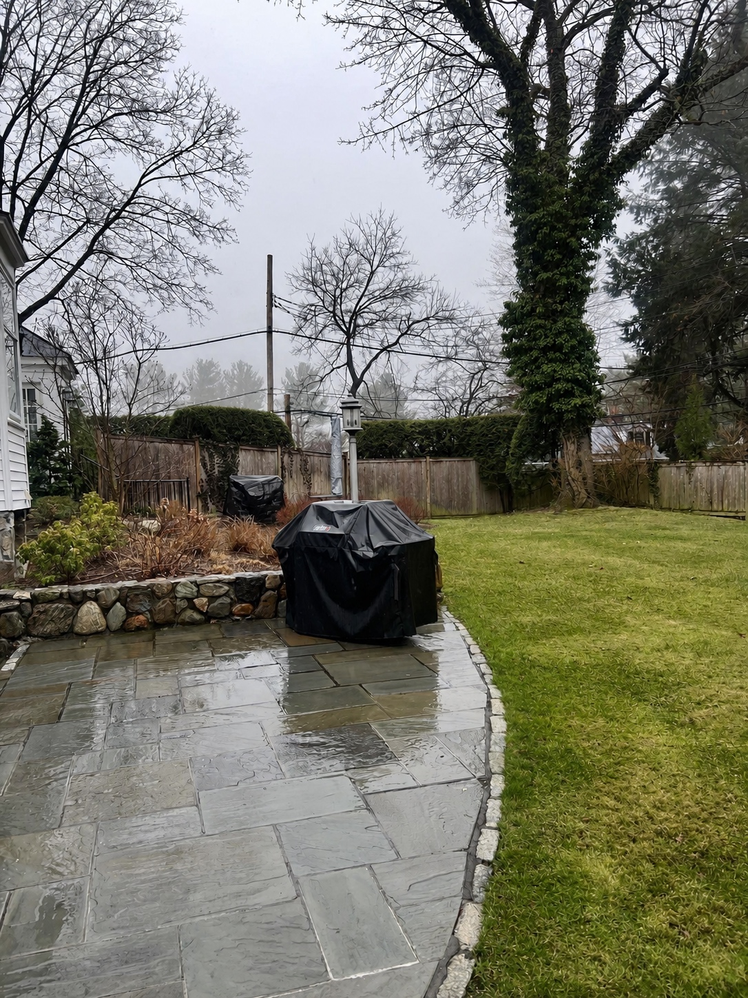 Pressure washed stone patio and garden path beside a lawn by Genesis Pro Painting
