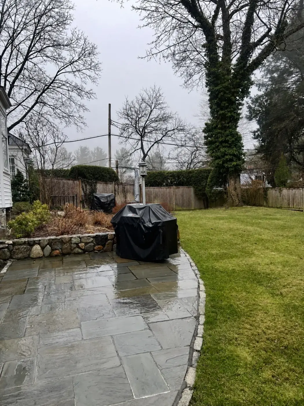 Pressure washed stone patio and garden path beside a lawn by Genesis Pro Painting