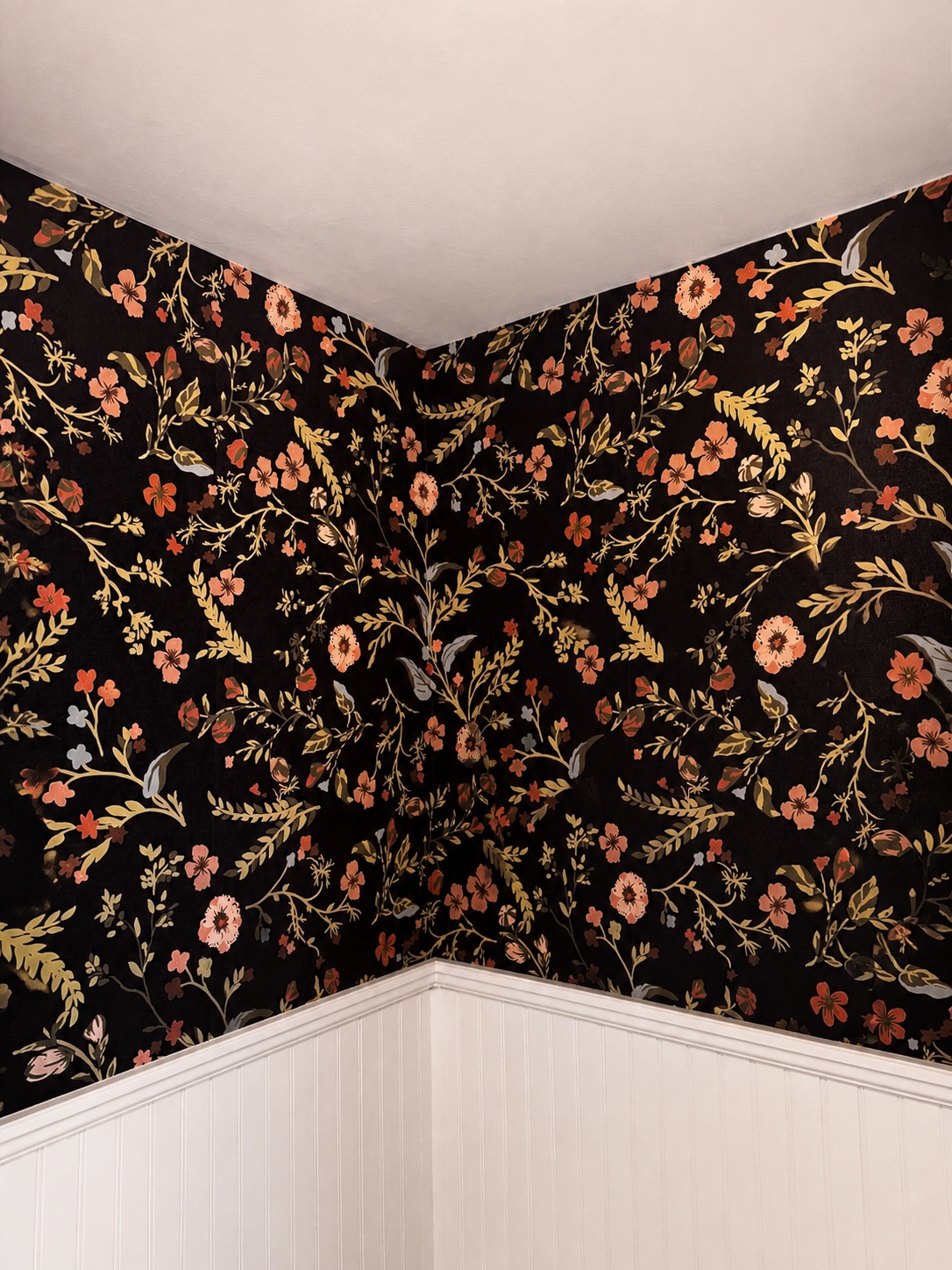 Black floral wallpaper in a powder room meeting white beadboard wainscoting at a clean corner by Genesis Pro Painting