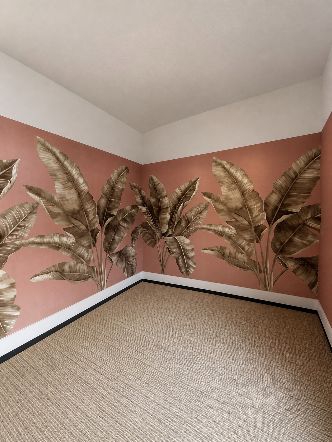 Terracotta banana leaf mural wallpaper carried around an inside corner with a black and white baseboard by Genesis Pro Painting