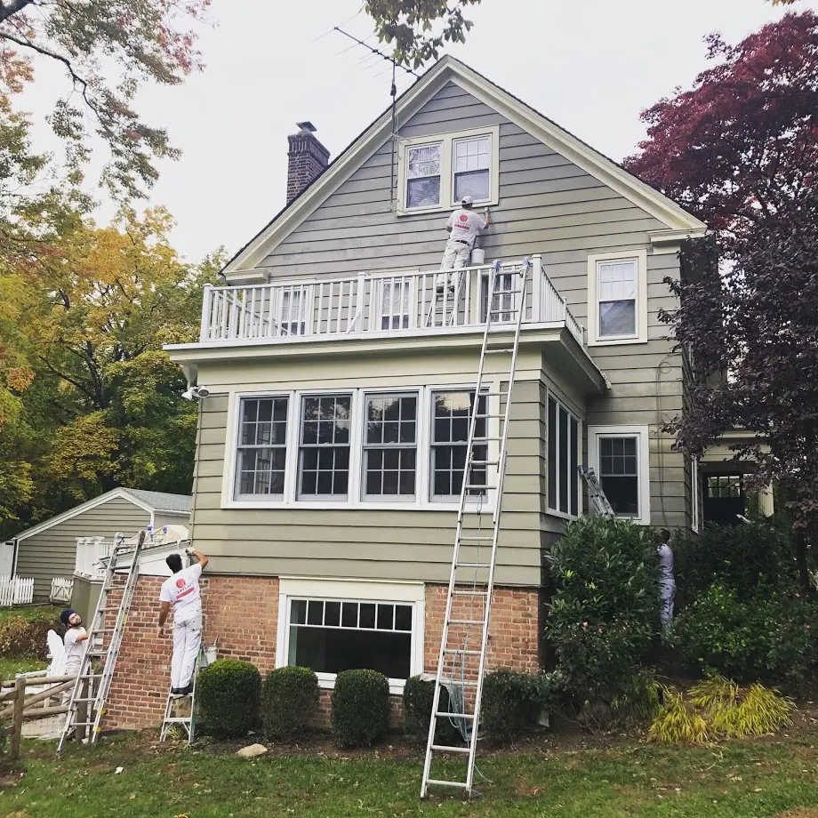 Light-colored wood siding and white trim on a multi-story house