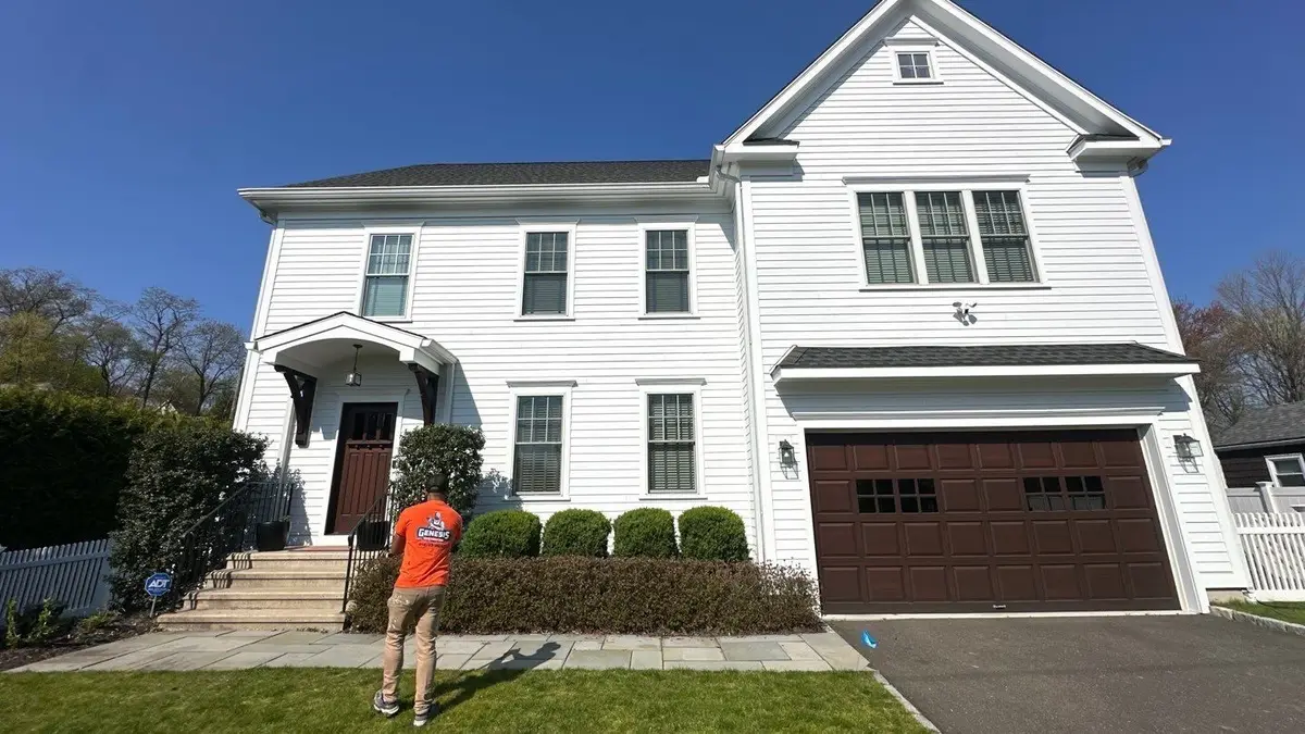 Finished white house exterior with contrasting dark garage doors