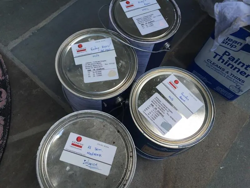 Paint cans labeled with the colors and products selected for a project