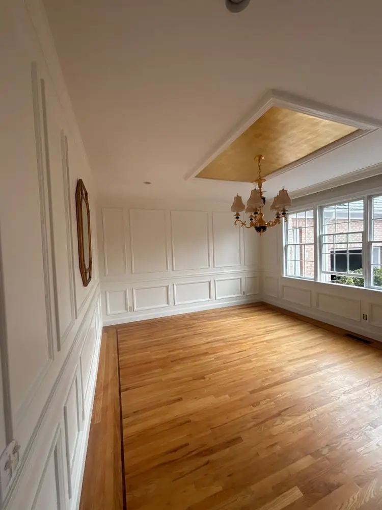 White paneled dining room with white window trim and a recessed ceiling