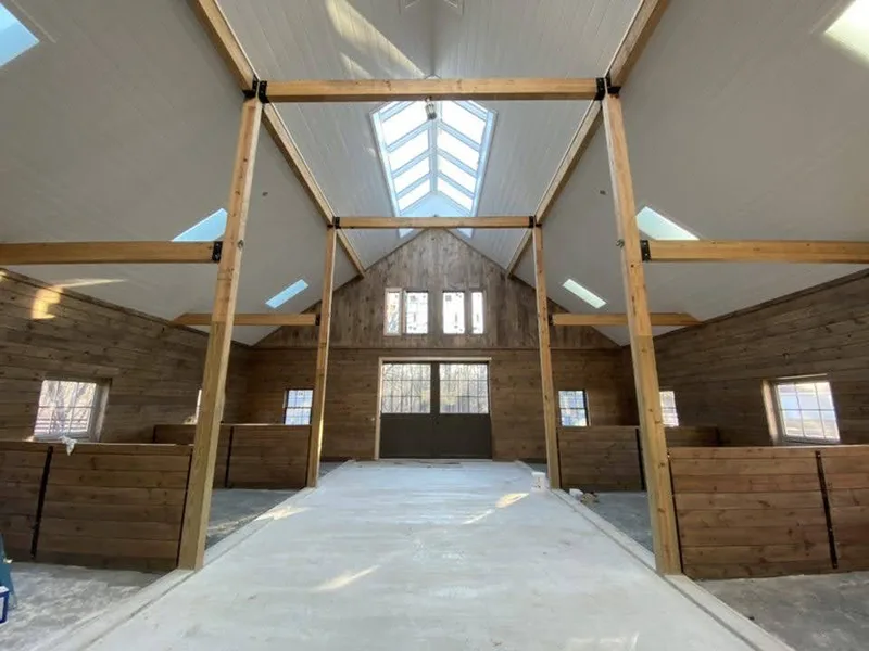 Interior with high ceilings, timber beams and protected flooring during painting preparation