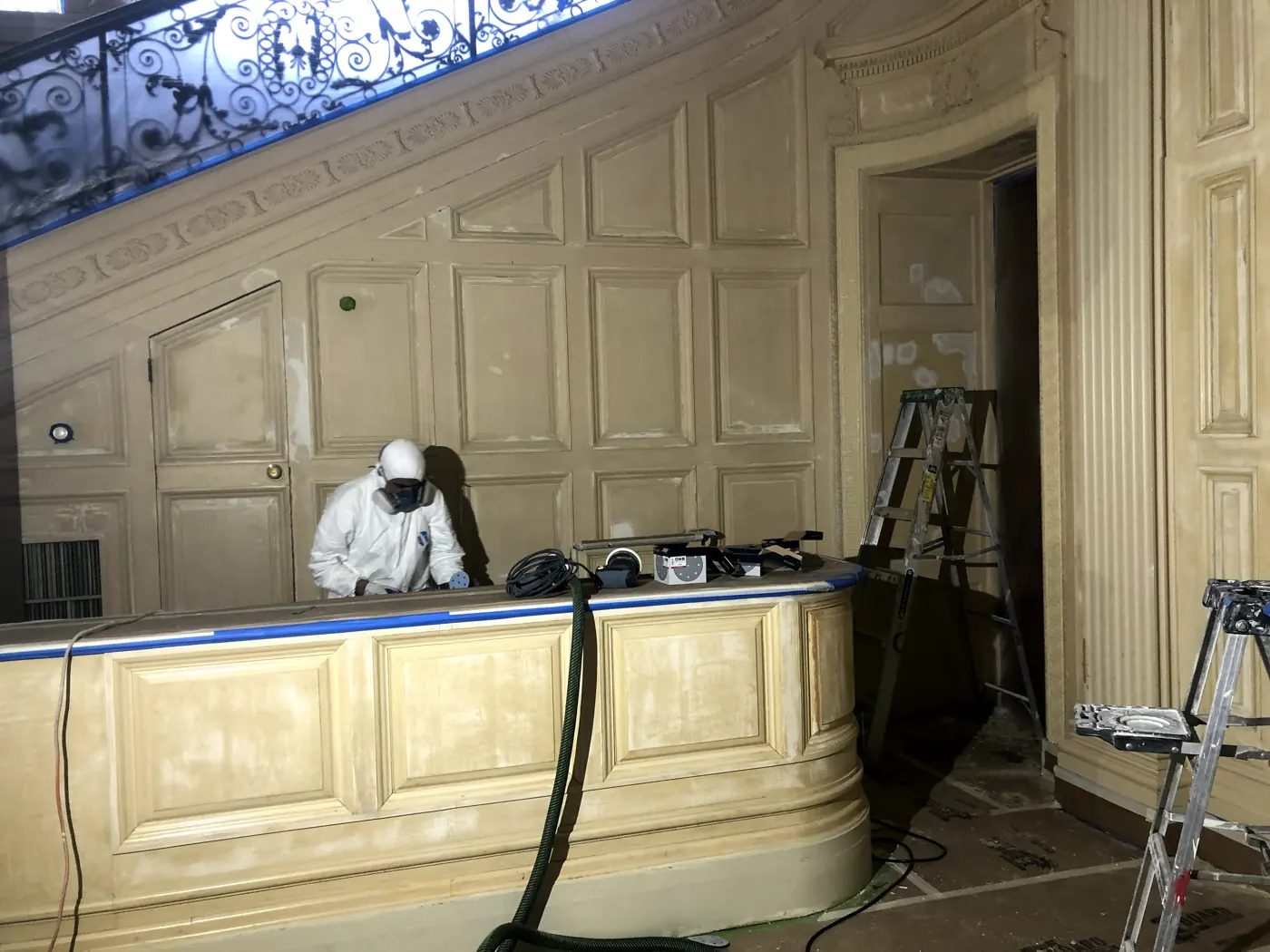 Painter preparing wood-paneled stairs and trim at Sleepy Hollow Country Club near Briarcliff Manor, NY