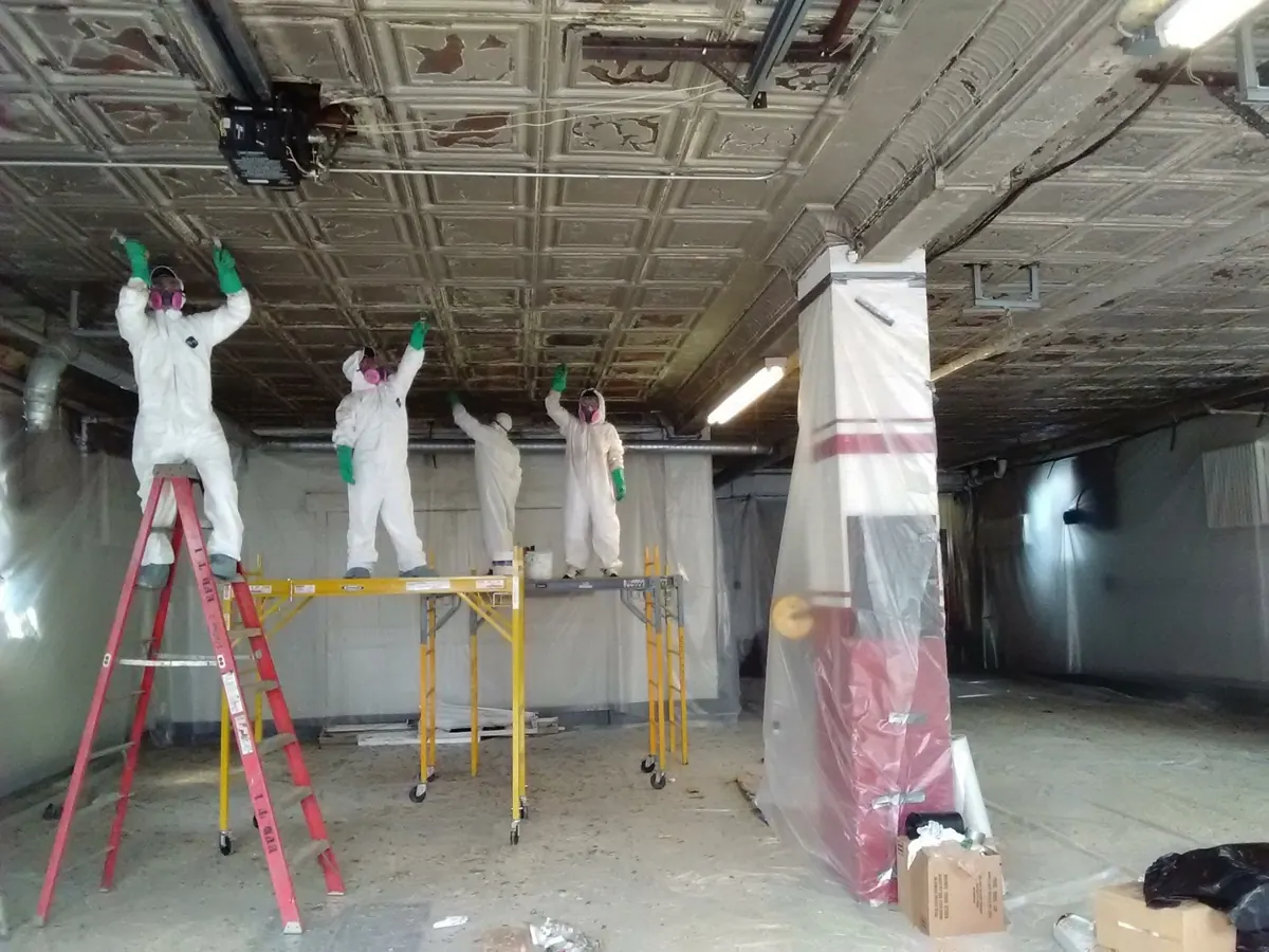 Painting crew working from scaffolding on a historic interior ceiling at a Tuckahoe, NY fire department facility